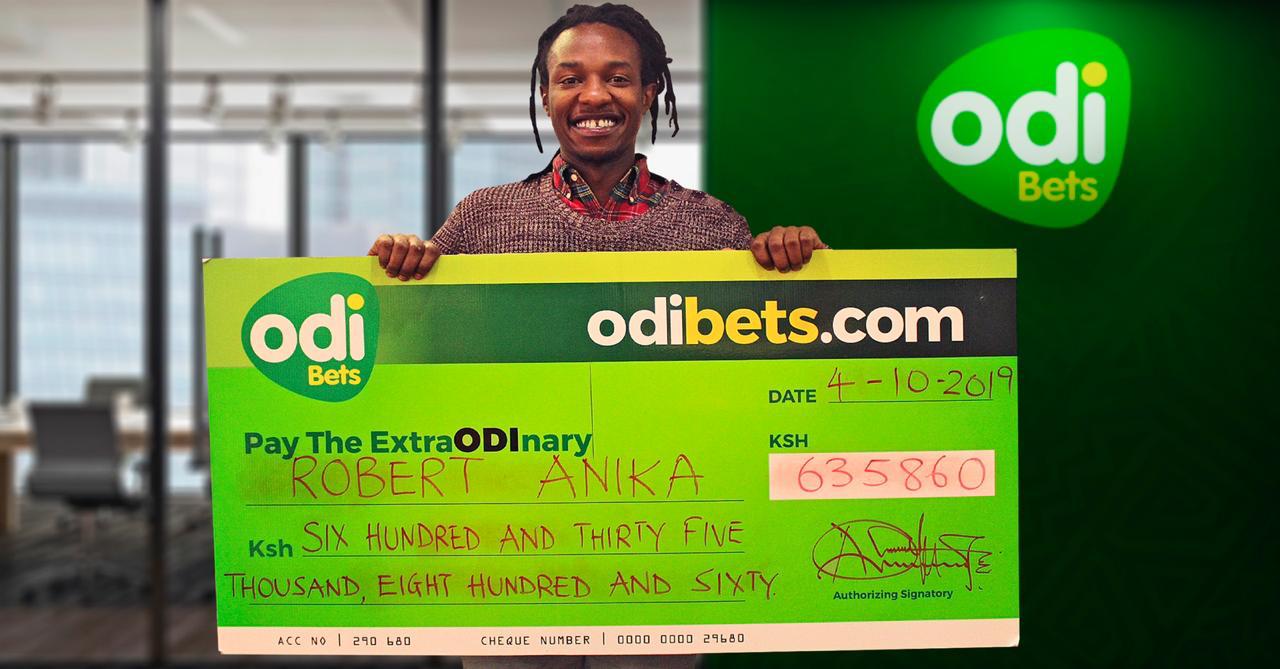 Image of Robert Anika shows off his dummy cheque after winning big on OdiBets
