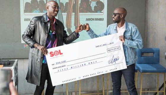 Bien (l) holds a dummy cheque as he poses with Sol Generation GM William Nanjero who unveiled him as the label's newest signee.