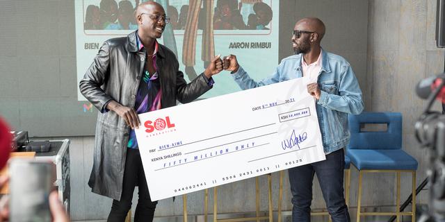 Bien (l) holds a dummy cheque as he poses with Sol Generation GM William Nanjero who unveiled him as the label's newest signee.
